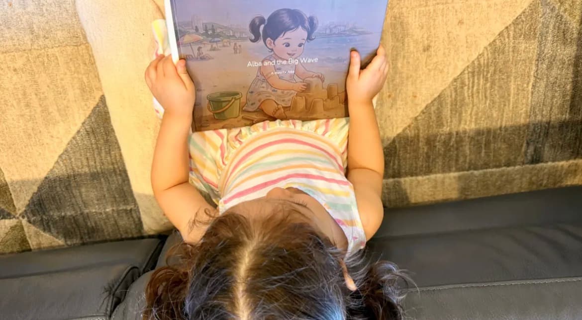 A child reading her personalised Almia hardcover storybook with her own illustrated likeness on the cover